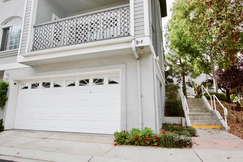A villa in Cape La Jolla Gardens has numberd D-F and with flowers on the bushes and trees