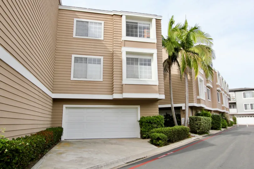 Three story brown building next to a palm tree near driveway in Cape La Jolla at La Jolla CA