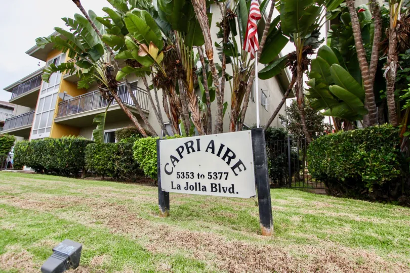 Worn down wooden sign in front of Capri Aire in La Jolla CA