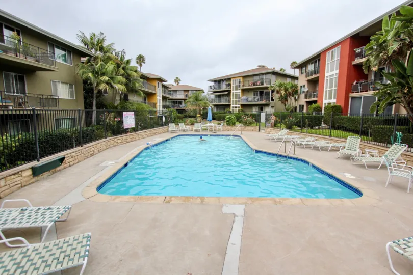 Pool surrounded by condos and furniture at Capri Aire in La Jolla CA