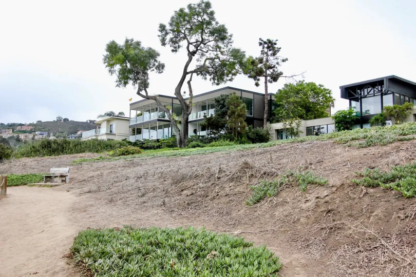 Grass covered dirt hillside at the base of condo units at Cliffs in La Jolla CA
