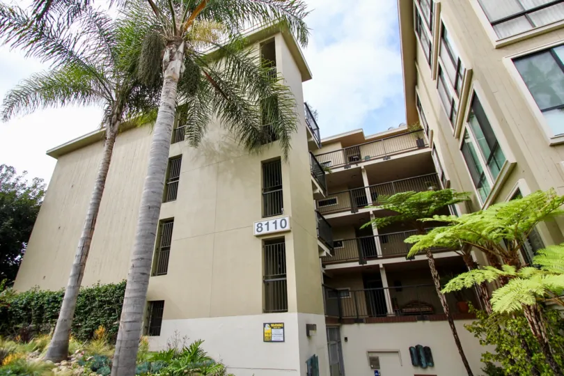 A side exterior view of the Clubdoniniums with exterior breezeways and tropical plant landscaping.