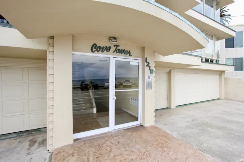 Glass door entrance with awning at Cove Towers in La Jolla California