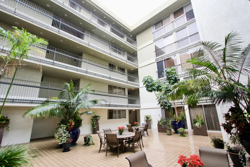 Apartment has three floors and has a light on the top and has flower pots
