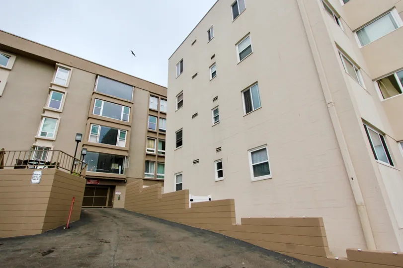 An apartment building with a long entrance to a garage at Edgewater Cove, La Jolla, CA