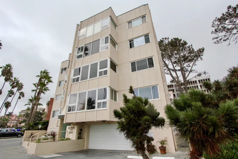 A large white garage under a five story residential building in La Jolla CA