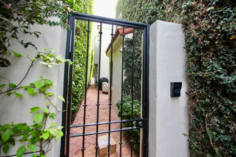Green creepers and bushes wall with security verification in El Paseo Grande.