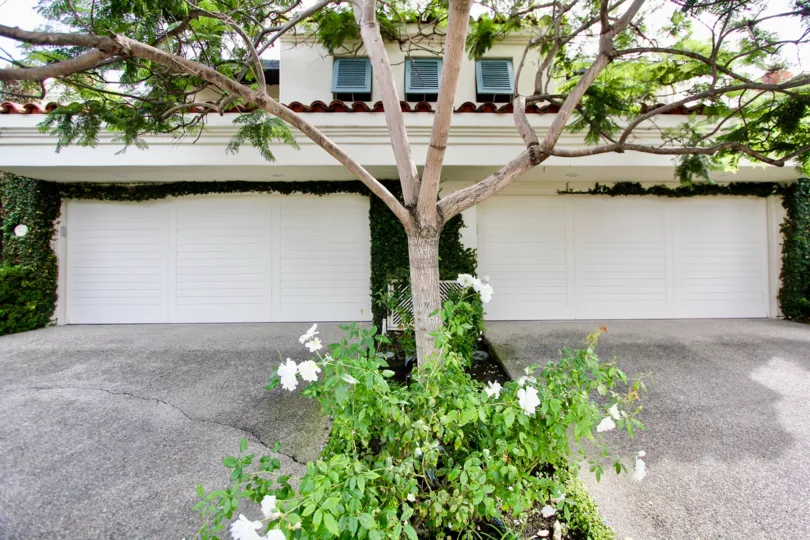 Two white garages with roses between them at El Paseo Grande in La Jolla CA