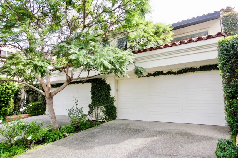 Two story homes with large garages & leafy trees at El Paseo Grande in La Jolla CA