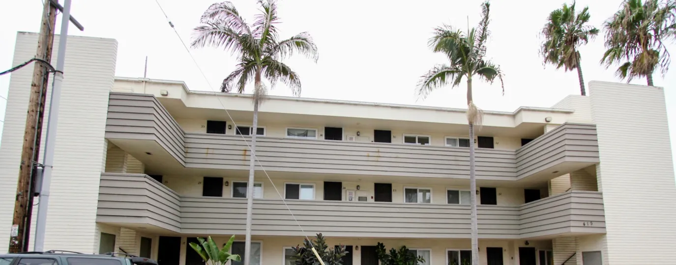 THE BUILDING IN THE FONTAINE BLEU WITH THE CAR PARKING, TREES, BANANA TREE, PLANTS