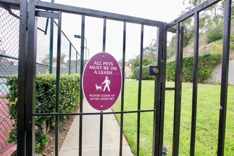 A sign reading "All pets must be on a leash on a gate"