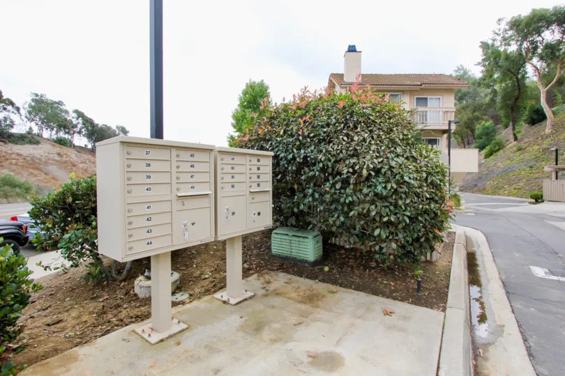 Mail boxes near bush and other plants inside La Jolla Hideaway in La Jolla CA