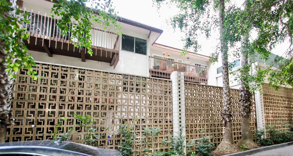 The Outside wall in the La Jolla Racquet Club with long trees and bushes