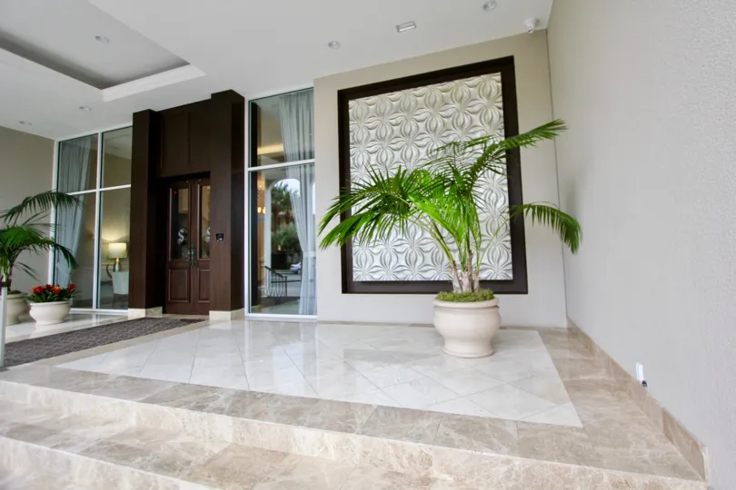 The Hall in the La Jolla Seville has flower pot on the two side of the door and with a room in front