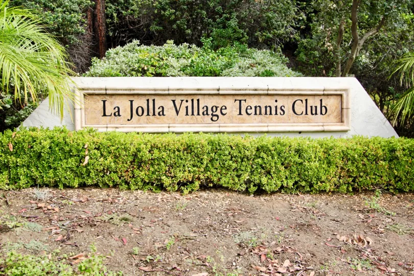 The wall in the La Jolla Village Tennis club is surrounded with Bushes and trees