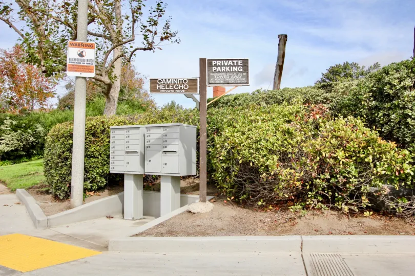 Two brown wooden signs next to two silver mail boxes in La Jolla Woods at La Jolla CA