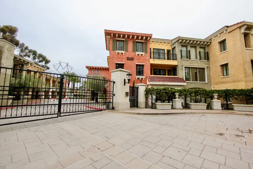 Several buildings behind a fence with landscaping in Montefaro