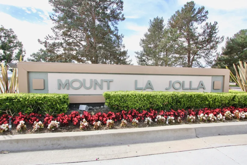 A large sign with trees in the background showing Mount La Jolla community.