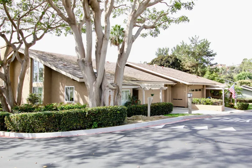 The outside of a unit in Mount La Jolla shwoing the multi-pane windows and shade trees.
