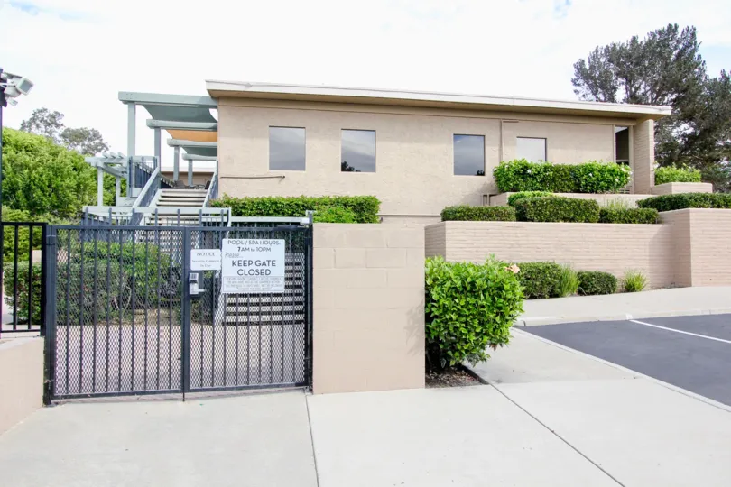 The Mount La Jolla with black closed gate and all around greenary