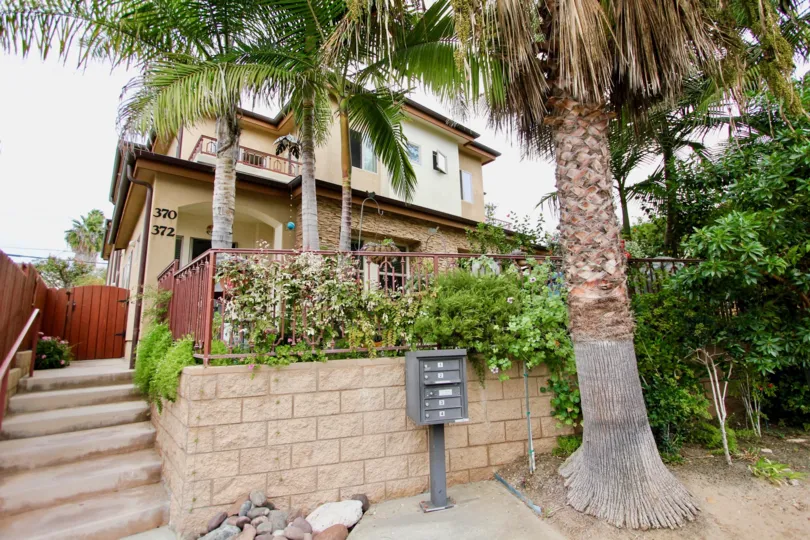 Stairway next to brick wall with palms in Playa Del Norte in La Jolla CA