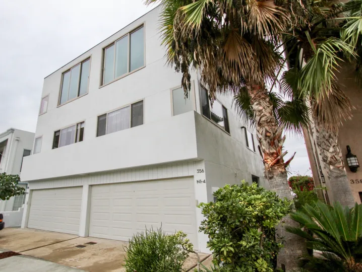 Two large gray garages at the base of a building in Prospect Terrace in La Jolla CA
