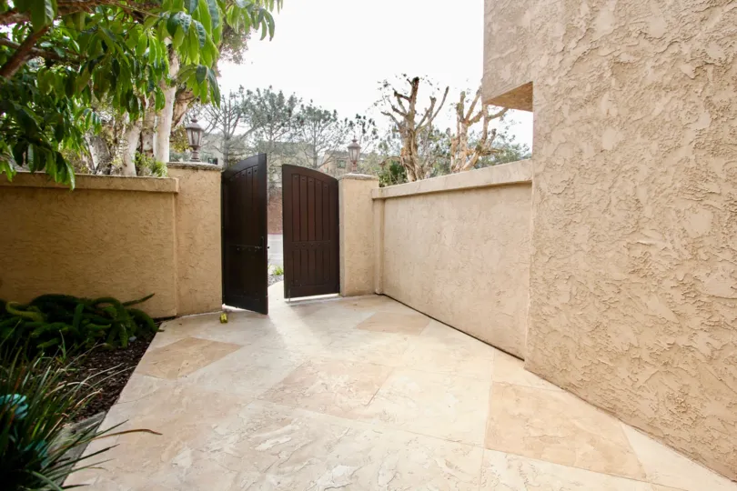 Brown wooden gateway leading to entrance of Sandpiper in La Jolla CA