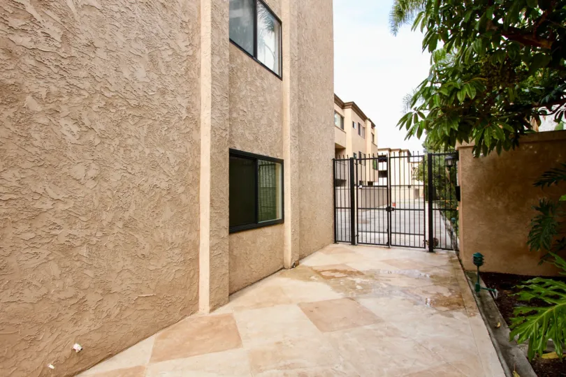A closed black gate sits at the end of a tiled walkway in the Sandpiper residential complex