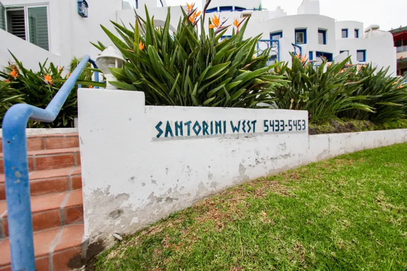 Large gray cement sign with blue writing in Santorini West in La Jolla CA