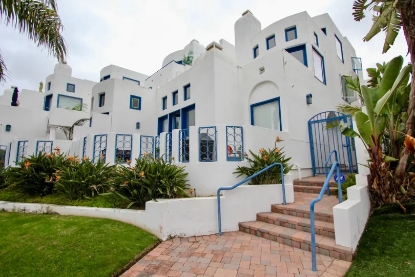Mediterranean inspired colors and architecture with brick lined entrance walkway at Santorini West