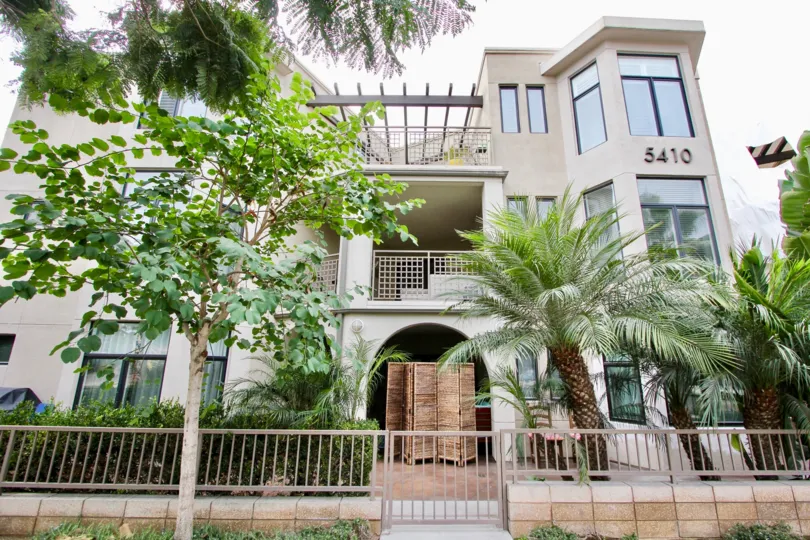 The Apartment with number 5410 has trees and plants near the entrance to inside
