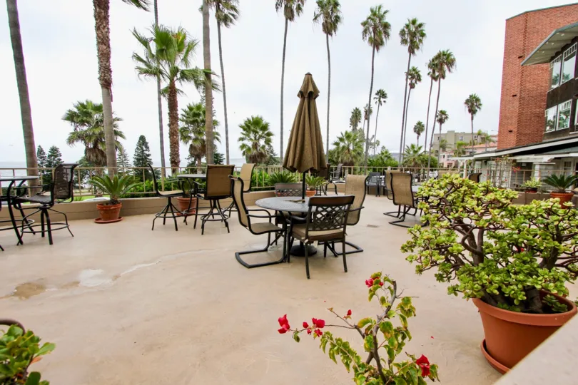 THE BUILDING IN THE SHOREPOINT WITH THE TABLES, FLOWER POT, TREES
