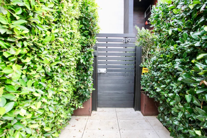 A door entrance marked with number 419 surround by bushes in Six by Sebastian Mariscal community.