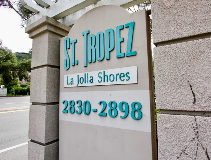 A large sign showing the community name of St Tropez in turquoise and gray.
