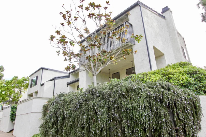 Three story home with gray railing inside The Woodlands in La Jolla CA