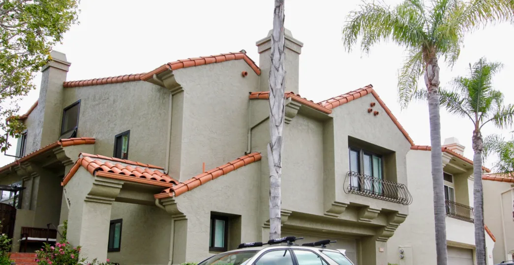 The house in the Ventana with plants, car and tall trees
