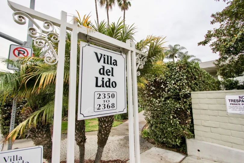 White sign with black writing outside of Villa De Lido in La Jolla California