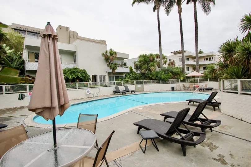 Kidney bean shaped swimming pool with chairs at Villa Del Lido in La Jolla CA