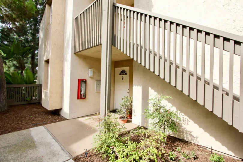 An entrance of a building in the Villa La Jolla with beautiful plants.