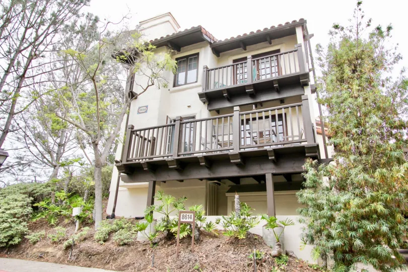 A yellow house with various trees surounding it at Villas Mallorca, La Jolla, CA