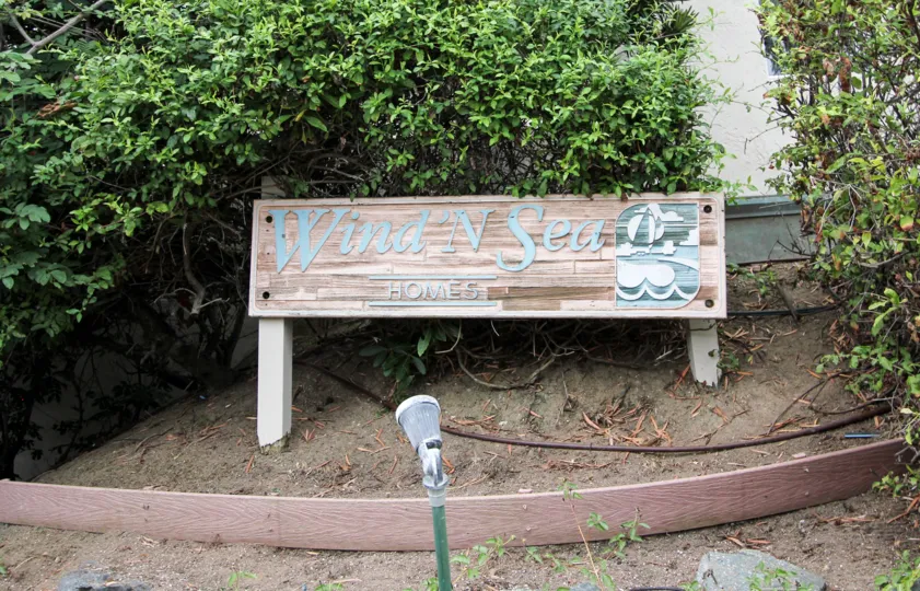 The board has Wind N Sea Homes with light covered with bushes and plants
