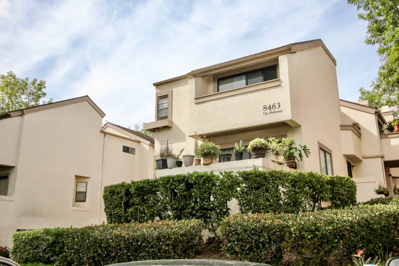 The beautiful, beige colored apartment complex of Via Mallorca located in the Woodlands West l community of La Jolla, California
