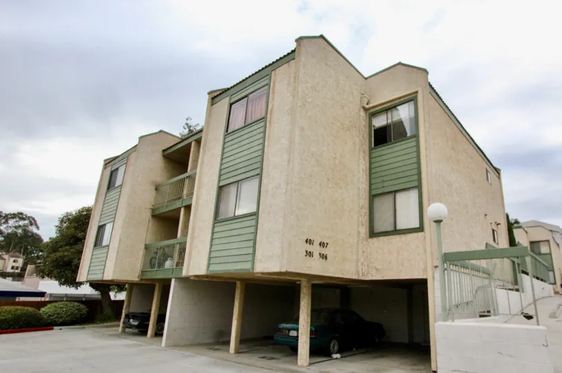 A cloudy day in the Cypress Plaza with residential building and plants.