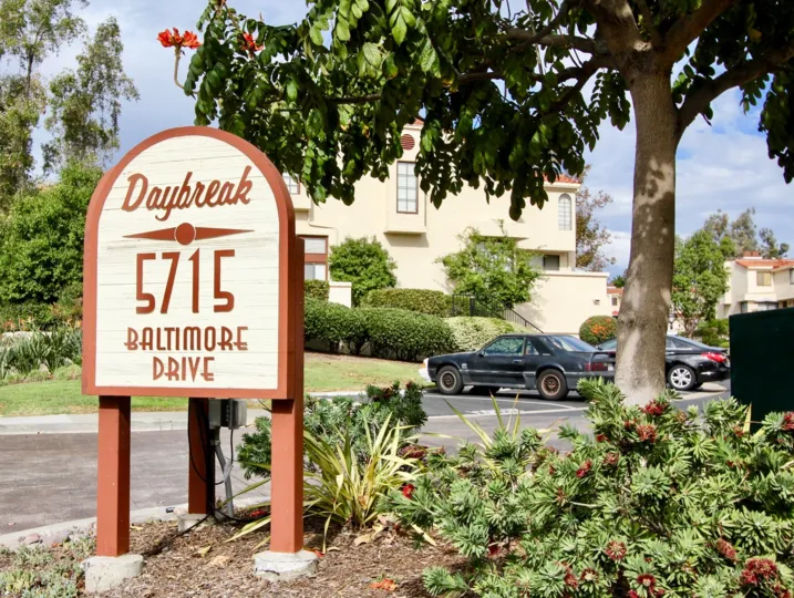 Daybreak apartment building with parking lots and green surroundings, perfect for leisure