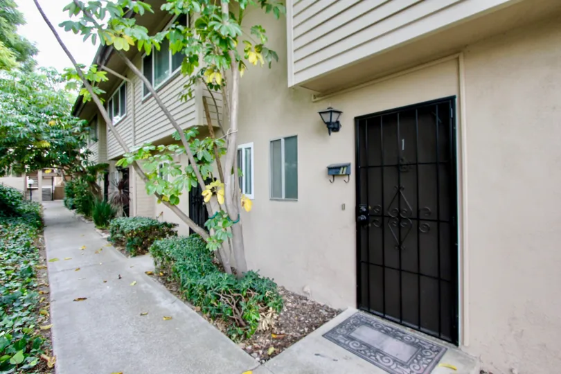 THE IMAGE SHOWS THAT HOUSE IN THE GROSSMONT VILLAGE WHICH HAS BEEN PATHWAY, PLANTS, TREES