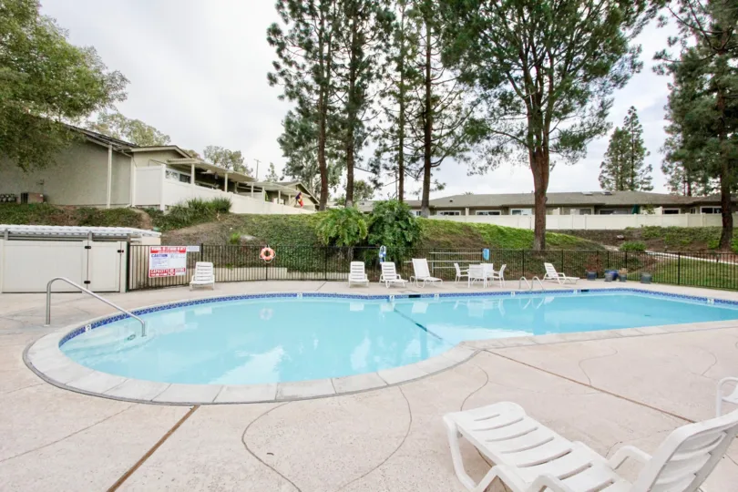The La Mesa Racquet & Swim Club looks cool and fresh with tall trees around and a chair by pool side