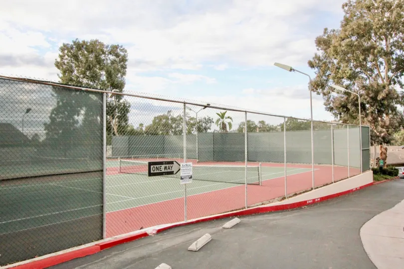 Black & white sign pointing to the right at a tennis court in La Mesa Racquet & Swim Club in La Mesa CA