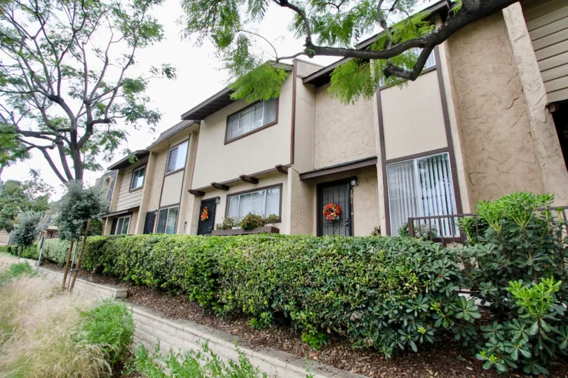 A sunny day in the La Mesa Village with residential building and trees.