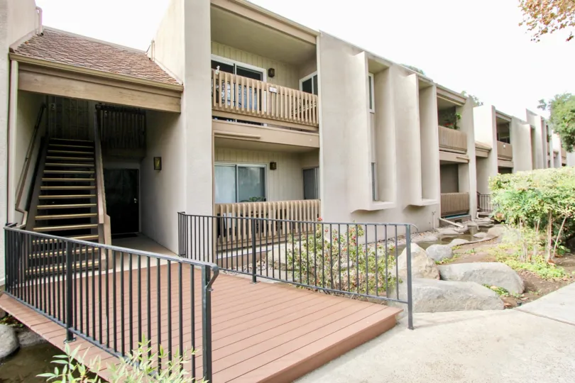Prominent water feature with pedestrian bridge, open riser stairs and front facing balconies at La Mirianda