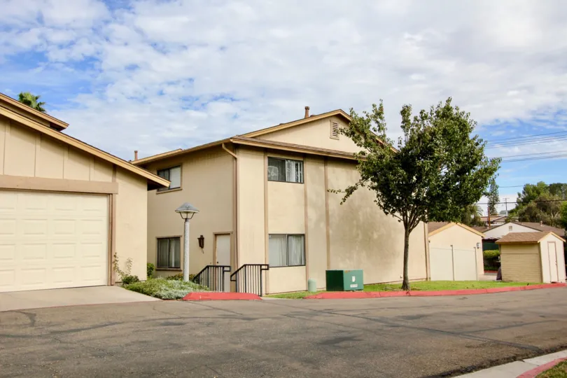 Two story condominiums with faded driveway in front of them at Lake Glen Park in La Mesa CA